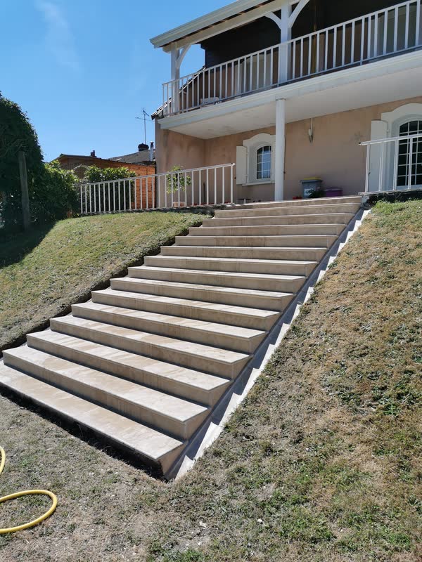 Grand escalier extérieur en pierre massive, chantier d'un artisan partenaire dans l'Yonne